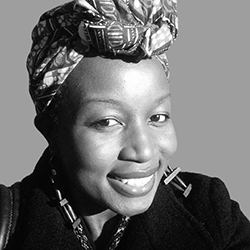 Black-and-white portrait of a Black writer. She's wearing a headscarf, possibly Ugandan, knotted over her forehead, long beaded earrings, and a black top. Her smile is joyful.