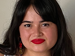 Portrait of a writer of Chinese and Filipina descent. It's a tight crop of her face. Joey has dark hair falling at least to her shoulders with bangs parted over her face. She has bright earrings and scarlet lipstick on.