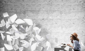 Stock art of a hipster-looking person typing as a flood of pages eject from their typewriter.